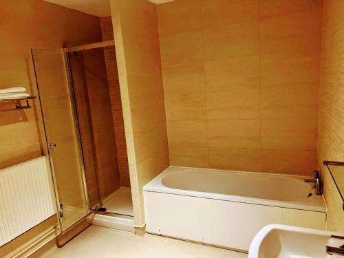 La salle de bains est pourvue d'une baignoire, d'une douche et d'un lavabo. dans l'établissement The Gillygate Bar and Rooms, à York