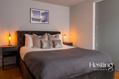 a bedroom with a large bed with pillows at Modern Luxury Apartment In The Heart of Henley in Henley on Thames