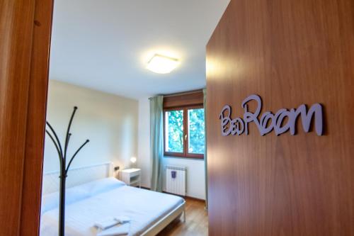 1 dormitorio con 1 cama y un cartel en la pared en monica Casa Vacanza en Busto Arsizio
