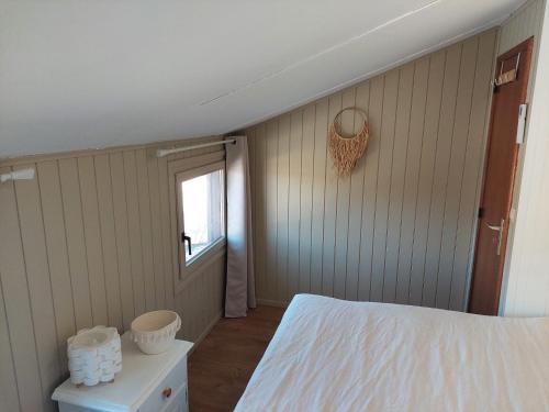 a bedroom with a white bed and a window at Maison à Portiragnes Plage - Résidence les Tamaris - Porte du Soleil - Prix piscine comprise in Portiragnes