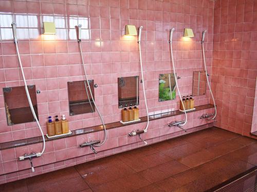uma casa de banho com uma parede em azulejos cor-de-rosa com espelhos em Hotel Akaboshitei - Vacation STAY 49562v em Echizen