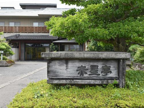 a sign sitting in the grass in front of a building at Hotel Akaboshitei - Vacation STAY 49562v in Echizen