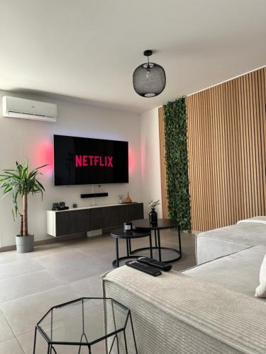 ein Wohnzimmer mit einem TV an der Wand in der Unterkunft Liège Luxe & Jacuzzi sous les étoiles in Saint-Nicolas