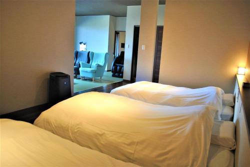 一関市にあるKajitsu no mori - Vacation STAY 53784vのベッド2台とリビングルームが備わるホテルルームです。