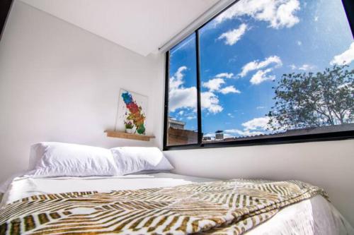 a bedroom with a bed and a large window at Apartamento en Chapinero - 209 in Bogotá