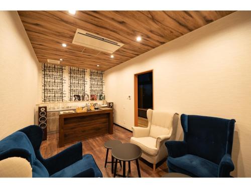 a living room with blue chairs and a table at Kajitsu no mori - Vacation STAY 53781v in Ichinoseki