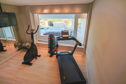 a gym with two exercise bikes and a treadmill at Villa do Vale Boutique Hotel in Blumenau
