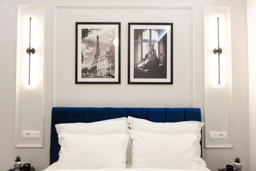 1 dormitorio con 3 cuadros en la pared sobre una cama en Luxurious Suite near New Bazaar, en Tirana