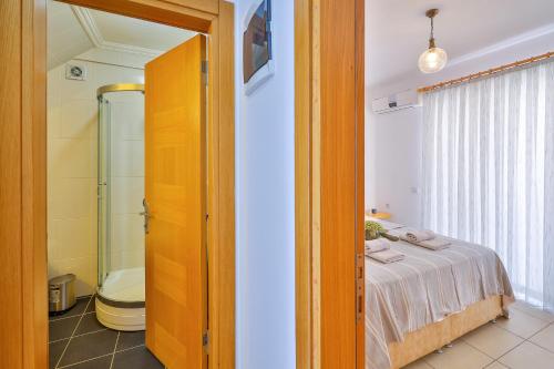 a bedroom with a bed and a bathroom with a shower at Apollo Apart in Kaş