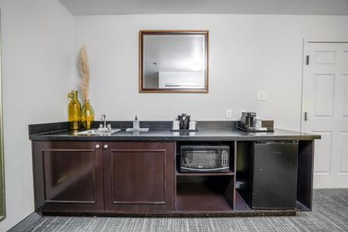a kitchen with a sink and a microwave at Country Inn & Suites by Radisson, Ontario at Ontario Mills, CA in Ontario
