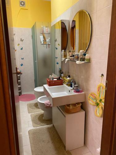 een badkamer met een wastafel, een toilet en een spiegel bij Soggiorno da Fiore in Monte Rubiaglio