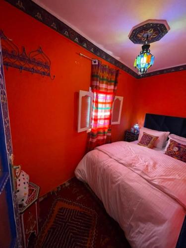 a bedroom with an orange wall with a bed in it at Charming Cozy house kasbah in Tangier