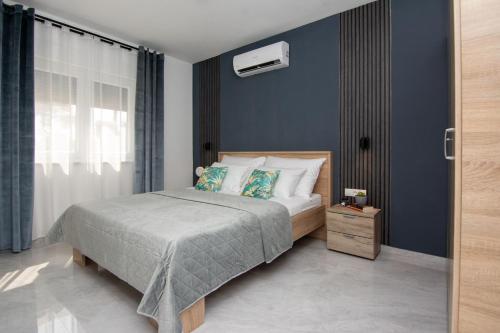 um quarto com uma cama e uma parede azul em Apartment Cosic em Vir