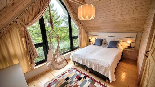 1 dormitorio con 1 hamaca en una habitación con ventanas en Domki Całoroczne nad Morzem Kraina Bałtyku, en Przewłoka
