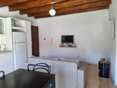 a living room with a couch and a tv on the wall at Departamento de Noah in Guaymallen