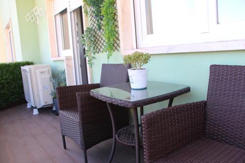 a patio table with chairs and a potted plant on it at ARRUDA GARDEN LUXURY APARTMENT with AC in Cascais