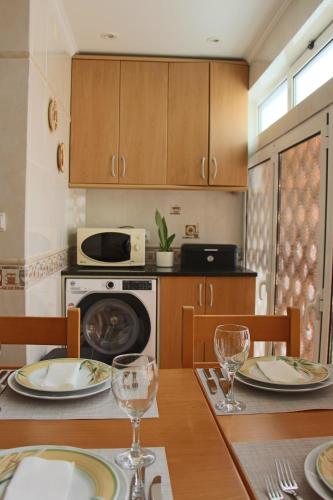 una cocina con una mesa con platos y copas de vino en ARRUDA LUXURY APARTMENT with AC, en Cascais