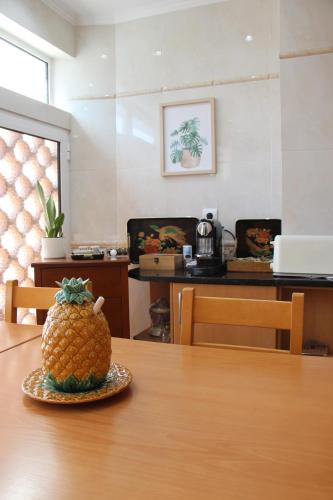 a pineapple sitting on top of a wooden table at ARRUDA GARDEN LUXURY APARTMENT with AC in Cascais