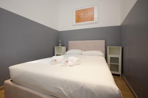 sypialnia z dużym białym łóżkiem z ręcznikami w obiekcie Charme&Design in Milano w Mediolanie
