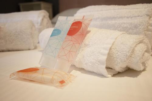 pudełko mydła obok ręczników na łóżku w obiekcie Charme&Design in Milano w Mediolanie