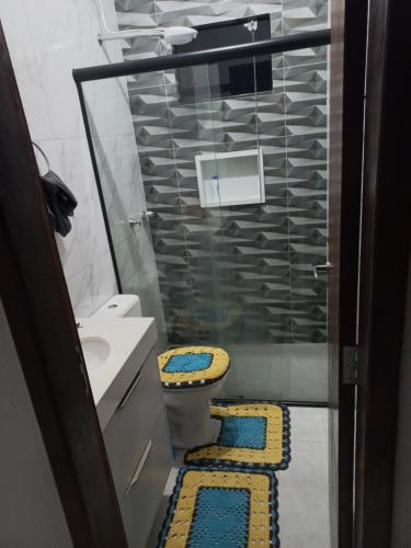 ein Bad mit einem WC, einem Waschbecken und einer Dusche in der Unterkunft Quarto privativo em casa de condomínio in Cuiabá