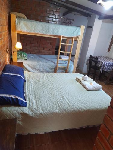 a bedroom with a bunk bed with a brick wall at Casa Hospedaje"Los Capulies" in Carhuaz