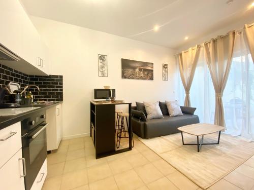 une cuisine et un salon avec un canapé et une table dans l'établissement Mohd'or 2 - Calais, à Calais