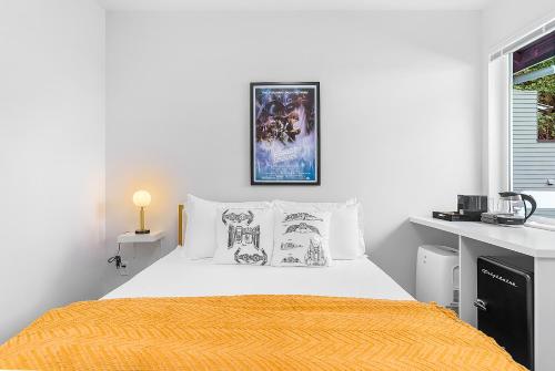 a white bedroom with a bed with a yellow blanket at Leia's Rebel Princess Suite in Seattle