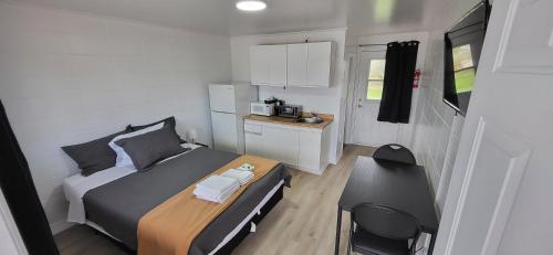a small bedroom with a bed and a desk at Happyland Inn in Orillia