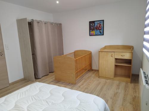 Schlafzimmer mit einem Bett, einer Kommode und einem Schreibtisch in der Unterkunft Gîte l'harmonie I in Fraize