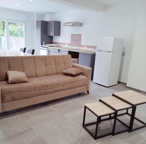 ein Wohnzimmer mit einem Sofa und einer Küche in der Unterkunft Gîte l'harmonie I in Fraize