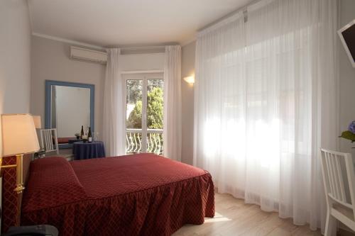 a bedroom with a red bed and a window at Hotel Il Gatto in Rapallo