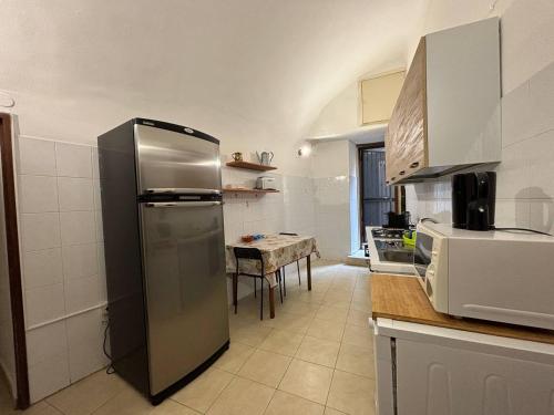 a kitchen with a stainless steel refrigerator and a table at Al Centro Storico in Catania