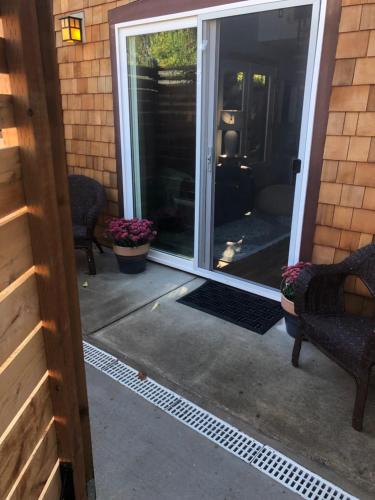 an open door to a patio with two chairs at Leos Loft in Eugene