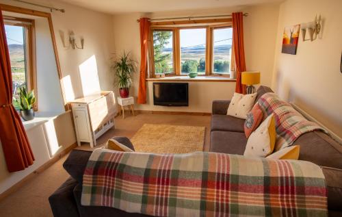 a living room with a couch and a tv at The High Croft in Rogart