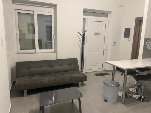 a living room with a leather chair and a table at Leo's Apartments in Koropíon