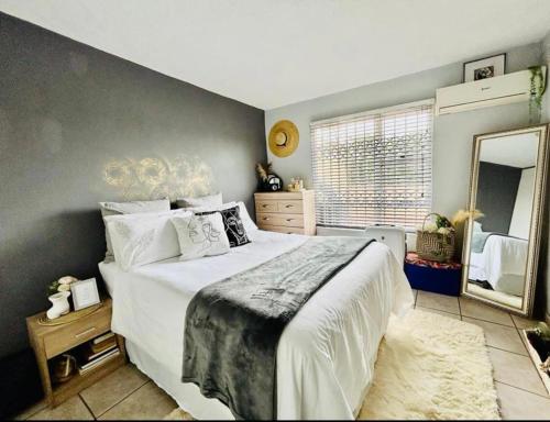 a bedroom with a large bed and a large mirror at Makwande Self-Catering Apartment in Durban