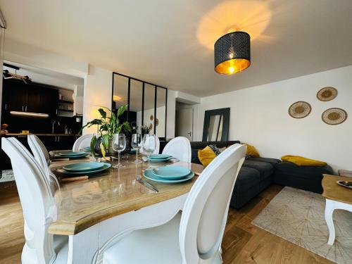 une salle à manger avec une table et des chaises blanches dans l'établissement Le vintage, à Tours