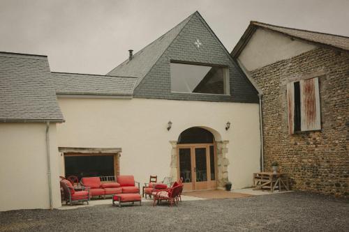 a house with red chairs and a building at Domaine de Berducq in Monein