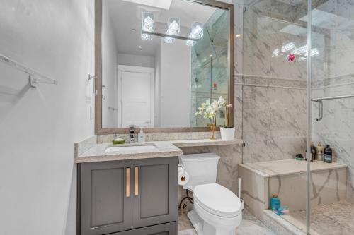 uma casa de banho com um chuveiro, um WC e um lavatório. em Vancouver West Cozy Retreat by Host Launch em Vancouver