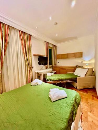 sypialnia z 2 zielonymi łóżkami i kanapą w obiekcie Auditorium Maxxi luxury suite Roma w Rzymie
