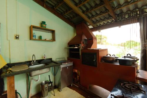 a kitchen with a sink and a stove and a window at HOSTEL DIKASA in Cuiabá