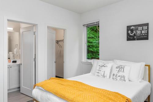 - une chambre blanche avec un lit et une couverture jaune dans l'établissement Yoda's Swamp Suite, à Seattle