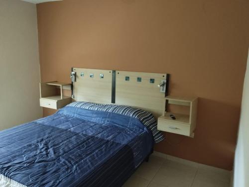 1 dormitorio con 1 cama azul y 2 estanterías en DEPARTAMENTO MUNI in 
