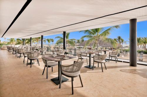 a patio with tables and chairs and palm trees at Live Aqua Punta Cana - All Inclusive - Adults Only in Punta Cana