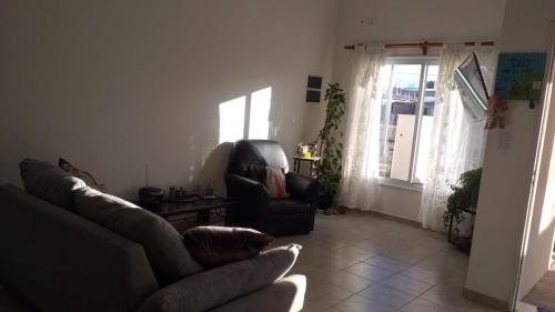 a living room with a couch and a chair and a window at Lo de Teresa P/5! in Malargüe