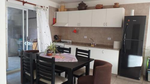 a kitchen with a table with chairs and a refrigerator at Lo de Teresa P/5! in Malargüe