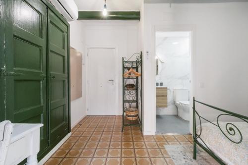 baño con puerta verde y aseo en La Casa Vella EL BEDORC, en Piera