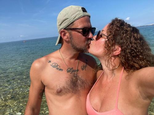 een man en vrouw in het water op het strand bij Apartmani Sollei in Petrcane