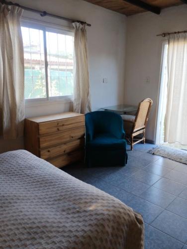 a bedroom with a bed and a desk and a chair at El naranjo in Mendoza